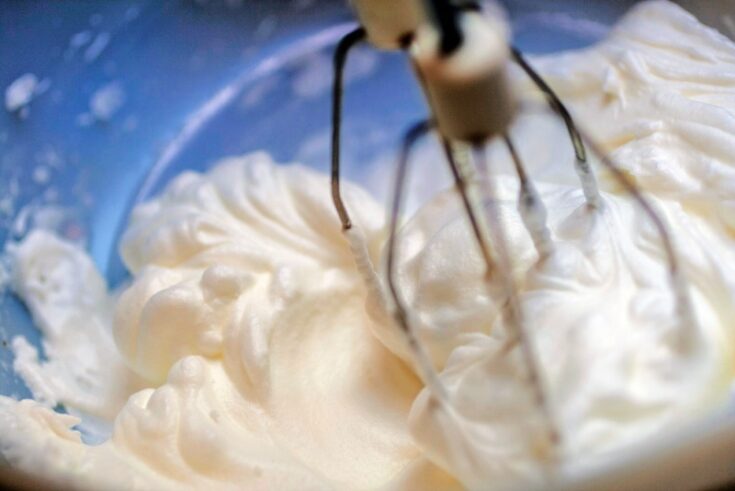 Mixing white egg cream in bowl with electric mixer, baking cake