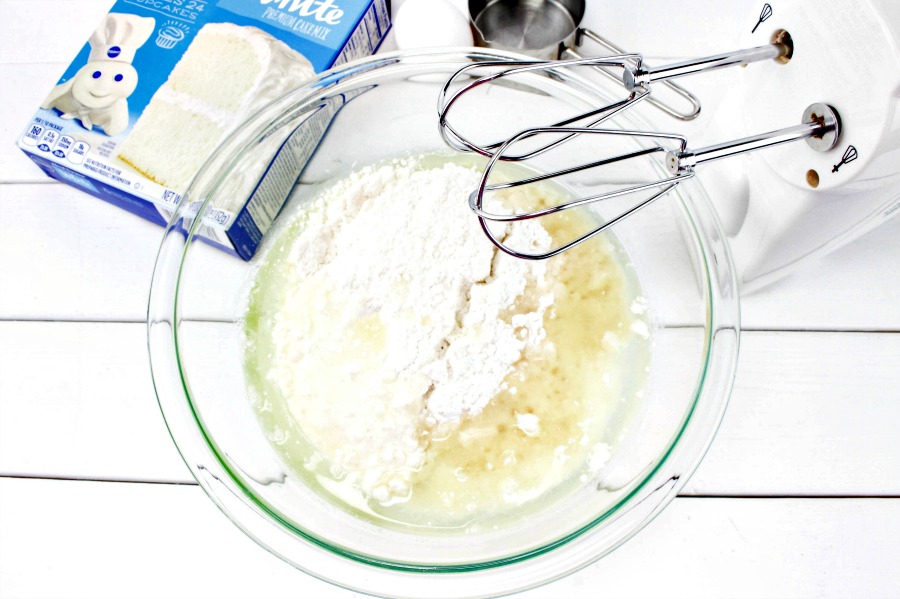 cake mix in a bowl with a mixer on table