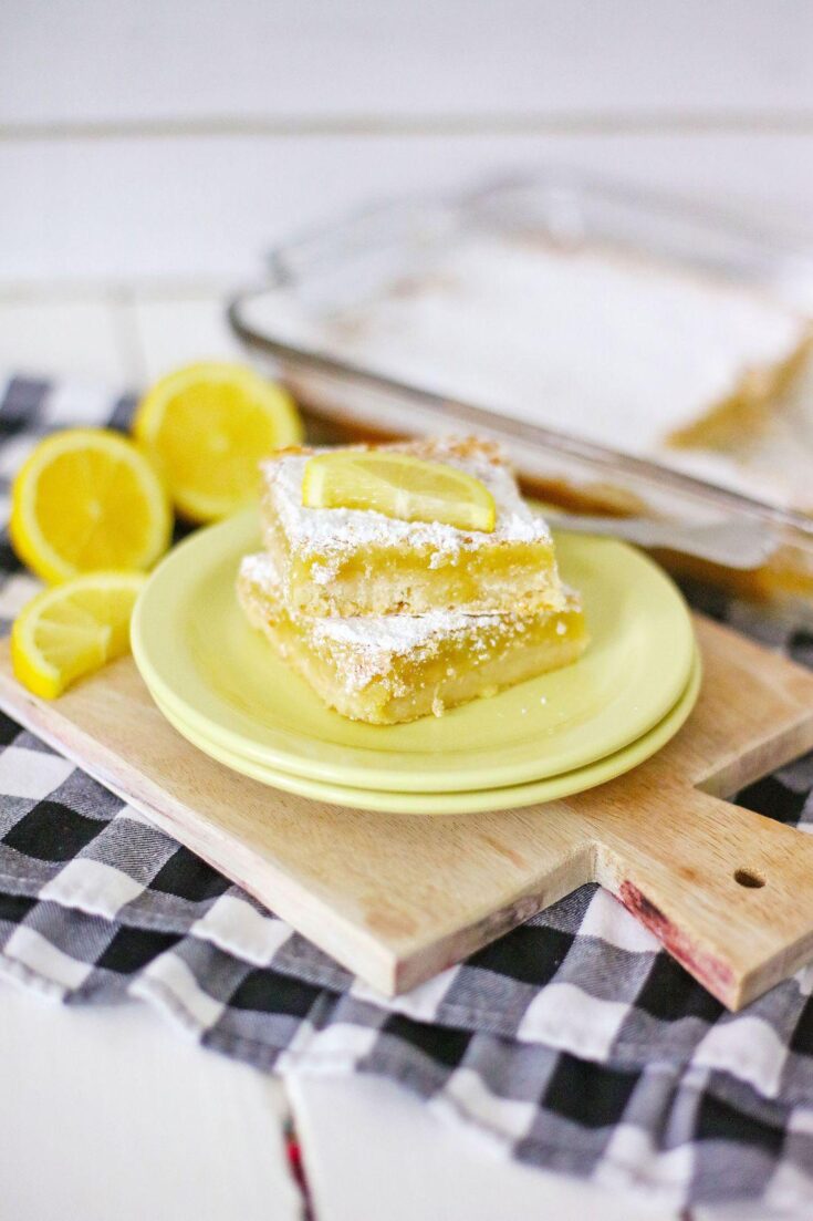 A shot of the final product, Homemade Lemon Bars, dusted with powdered sugar and cut into squares.