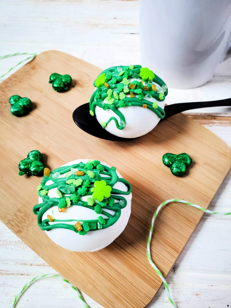 St. Patrick’s Day Hot Cocoa Bombs on a black spoon