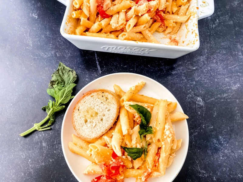 pasta on a white plate with a slice of bread