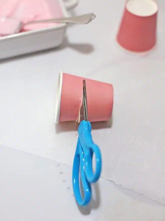 Bailey’s Strawberry and Cream Cocoa Cups, a Valentine's Day treat, on a table next to a pair of scissors.